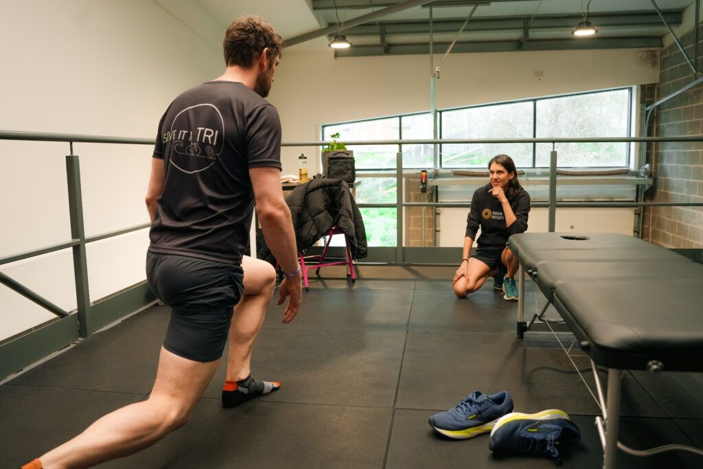 Man completing stretches as physio looks on