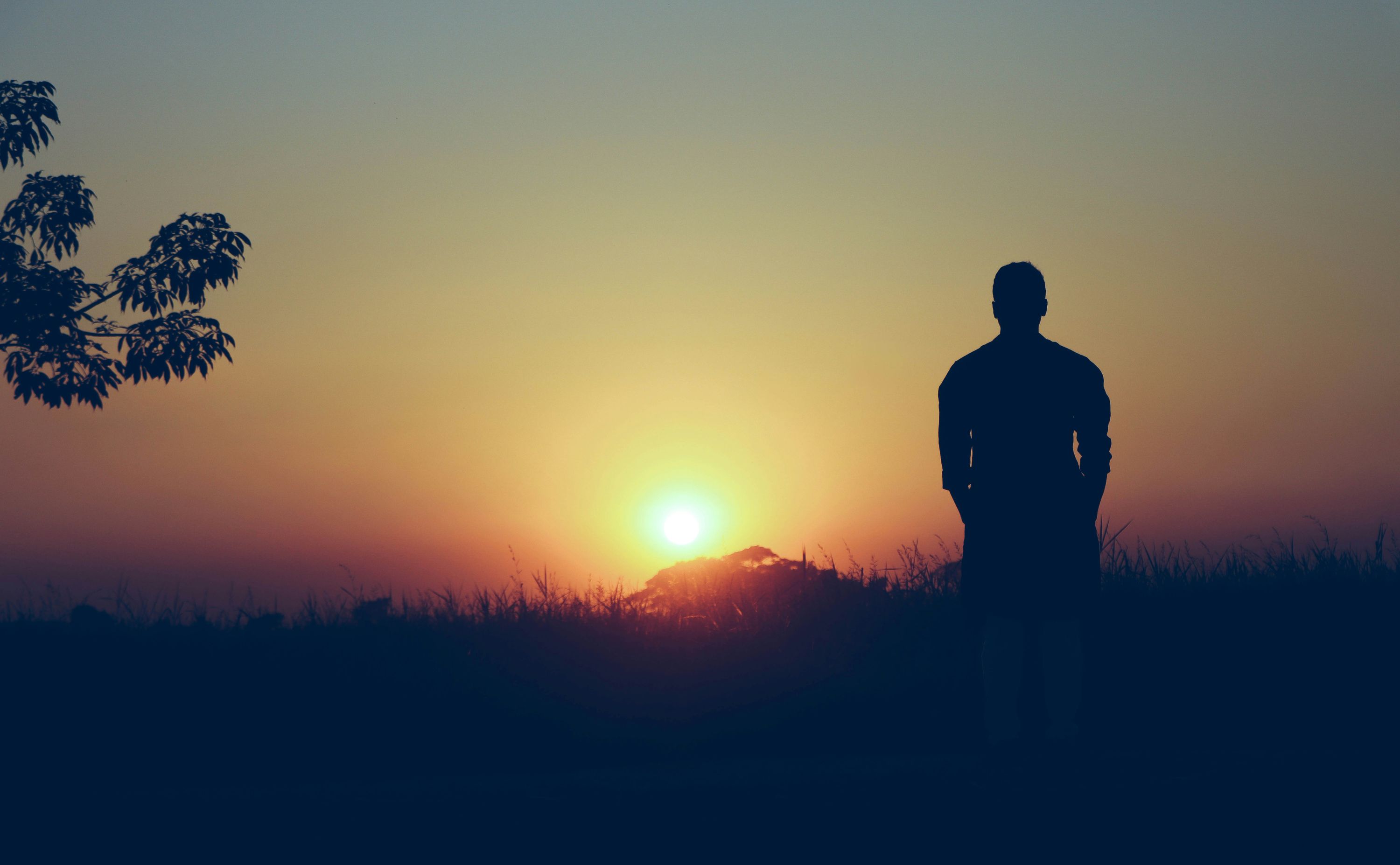 Man staring into the sunset alone.